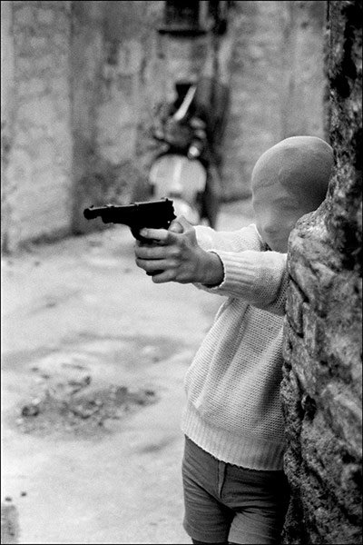 Letizia Battaglia - Near the church of Sants Chiara, boy with a gun, Parlermo 1982