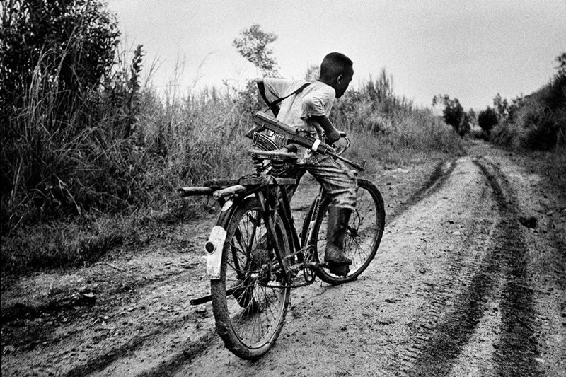 Marcus Bleasdale - A child soldier rides back to his base, Northeastern Congo 2003