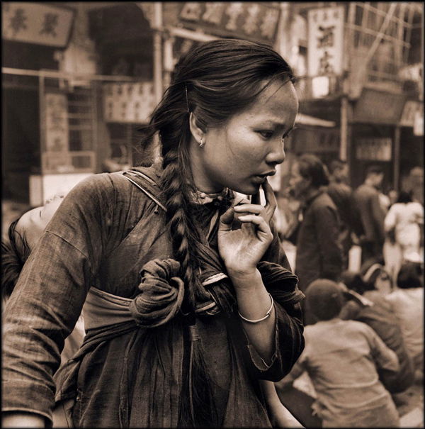 Hedda Morrison - Young mother carrying a child on her back in the market, Hong Kong 1946