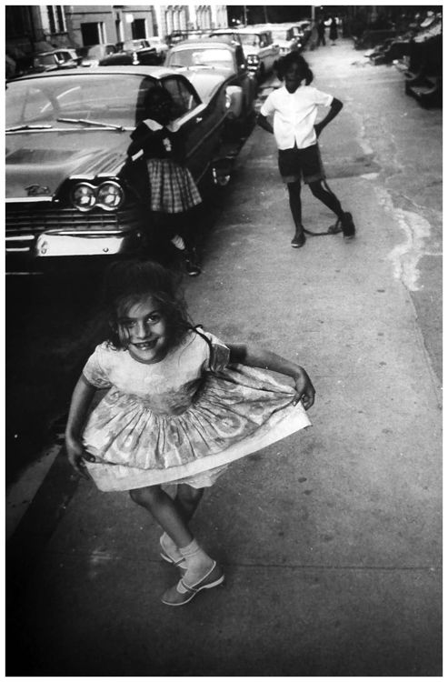 Garry Winogrand - Little girl does a curtsy on the sidewalk