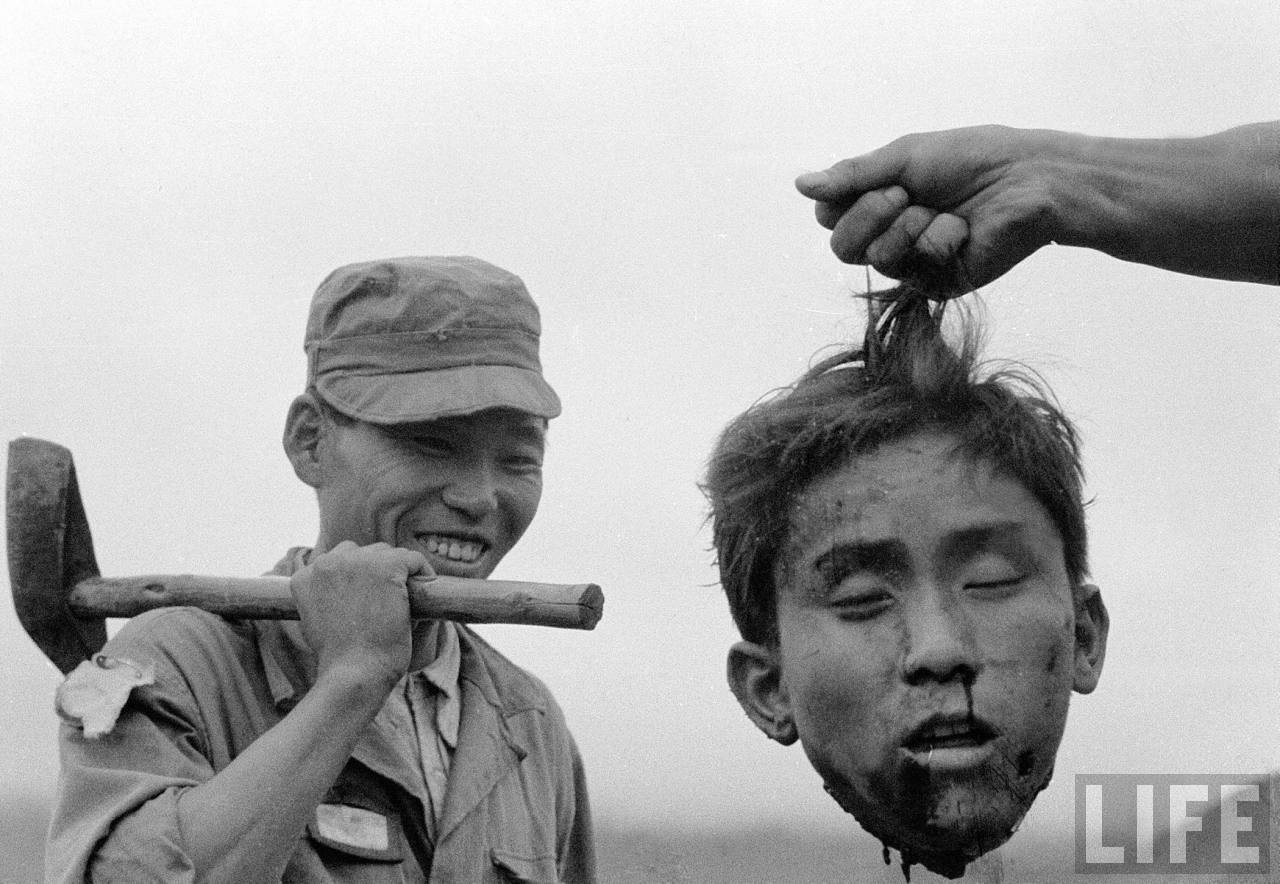 Margaret Bourke-White - A member of the South Korean National Police holds the severed head of a North Korean communist guerrilla during the Korean War 1952