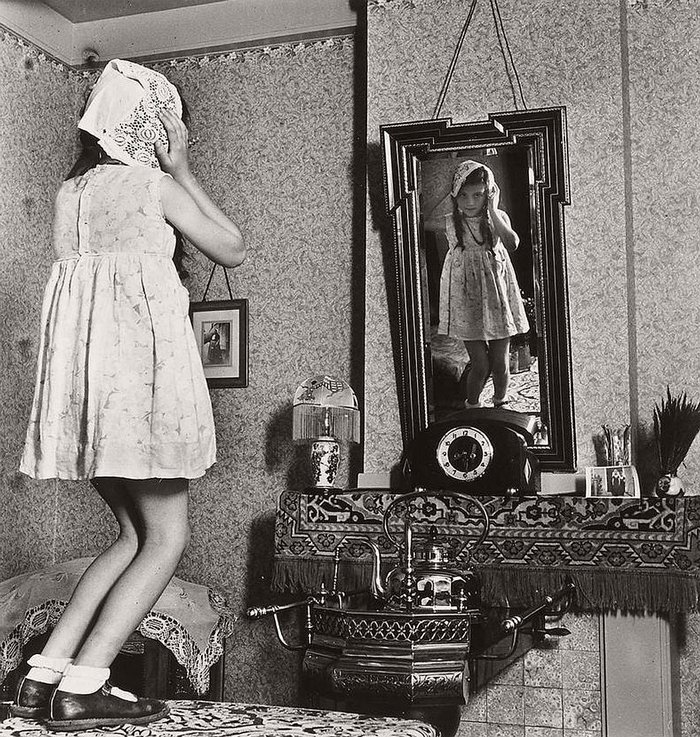 Eva Besnyő - Fille debout sur une table avec un bonnet de Zélande devant le miroir, Westkapelle 1939