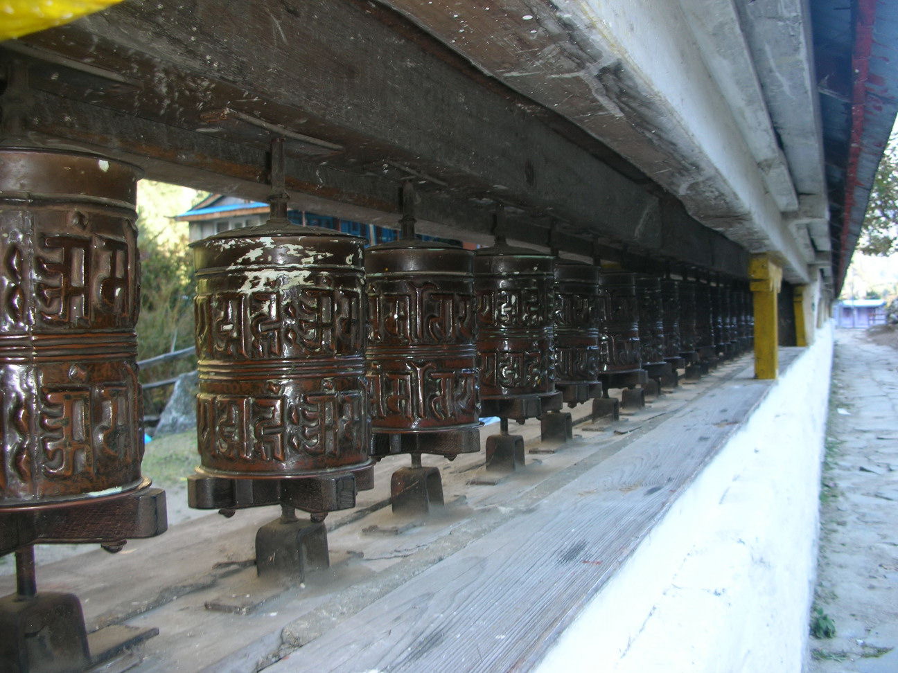 REVOLVING PRAYER DRUMS WHICH YOU TURN AS YOU PASS BY