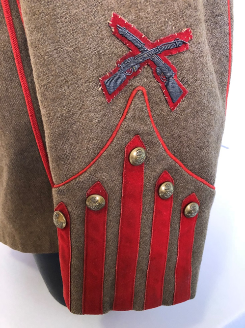 Tunic cuff detail with  The Crossed Rifles badge is a proficiency badge for musketry worn by Sergeants and is referenced as 23A in Denis Edwards and David Langley's: British Army Proficiency Badges, The Sherwood Press, Nottingham, 1984.