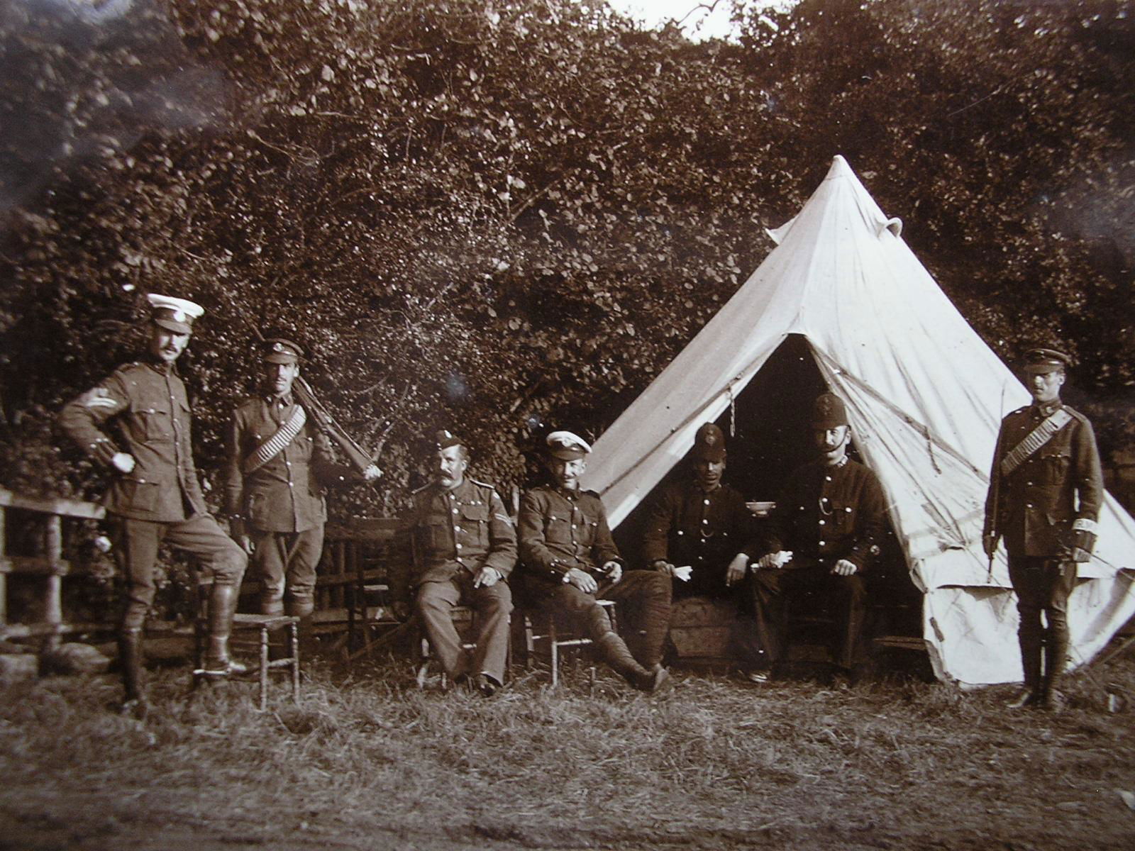 Quarter Guard tent with a 'C' Squadron (Australasian) Corporal and two Trooper of the King’s Colonials guarding ‘prisoners’ (two Buckinghamshire and Hertfordshire policemen and a Royal Army Medical Corps Corporal) at Latimer Camp in 1903. The King’s Colonial’s Trooper on the far right is wearing a cloth band with RMP for Regimental Military Police around his lower left sleeve cuff.