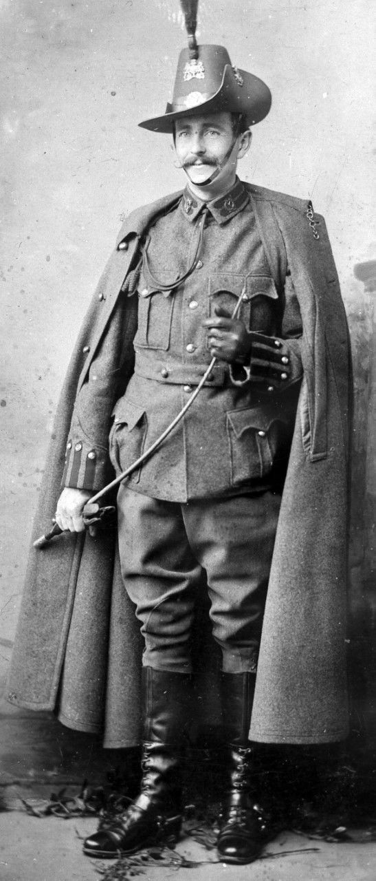 Private) Angel of ‘C’ Squadron (Australasian) of the 4th County of London (King’s Colonials) Imperial Yeomanry in Full Dress uniform (Review Order 1901-1904) with cloak, gloves and whip circa 1903. Private Angel is wearing three headdress badges and first pattern collar badges of the King’s Colonials as described in  the King's Colonials badge sections (R. J. Smith collection).