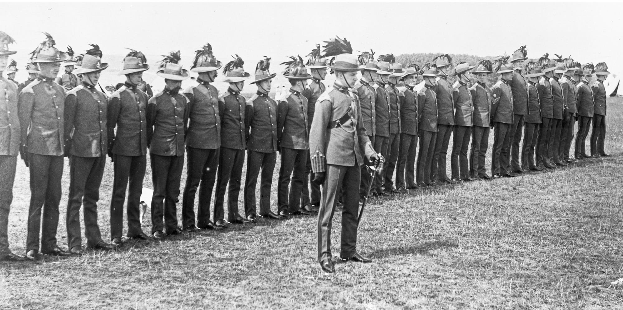 Full Dress uniform including Second Pattern headdress of an Officer and Other Ranks of ‘C’ Squadron (Australian) on church parade of the King’s Colonials Imperial Yeomanry circa 1905-06. The Officer and Other Ranks are wearing ‘C’ Squadron (Australian) headdress and collar badges (R. J. Smith collection).