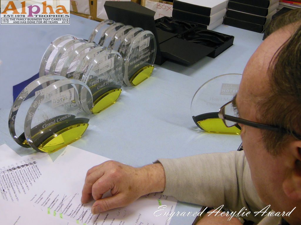 Engraver Looking At Acrylic Trophies