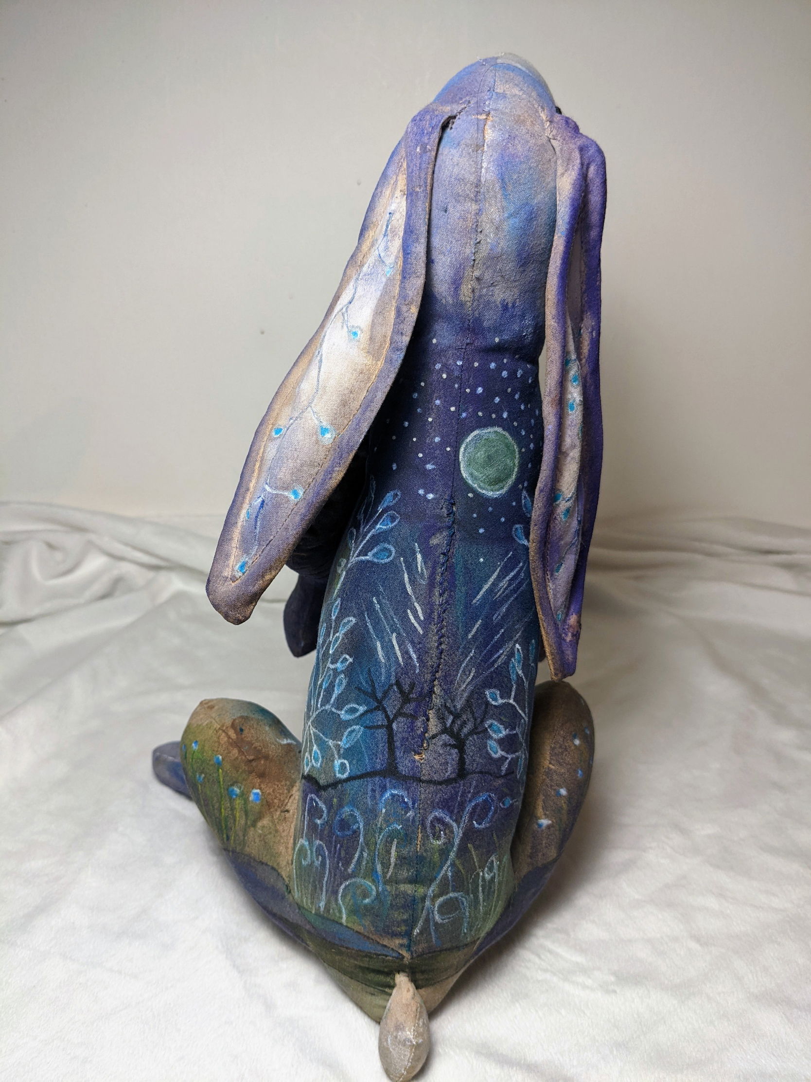 Little vlue hare textile sculpture with a leaves and the moon on its back