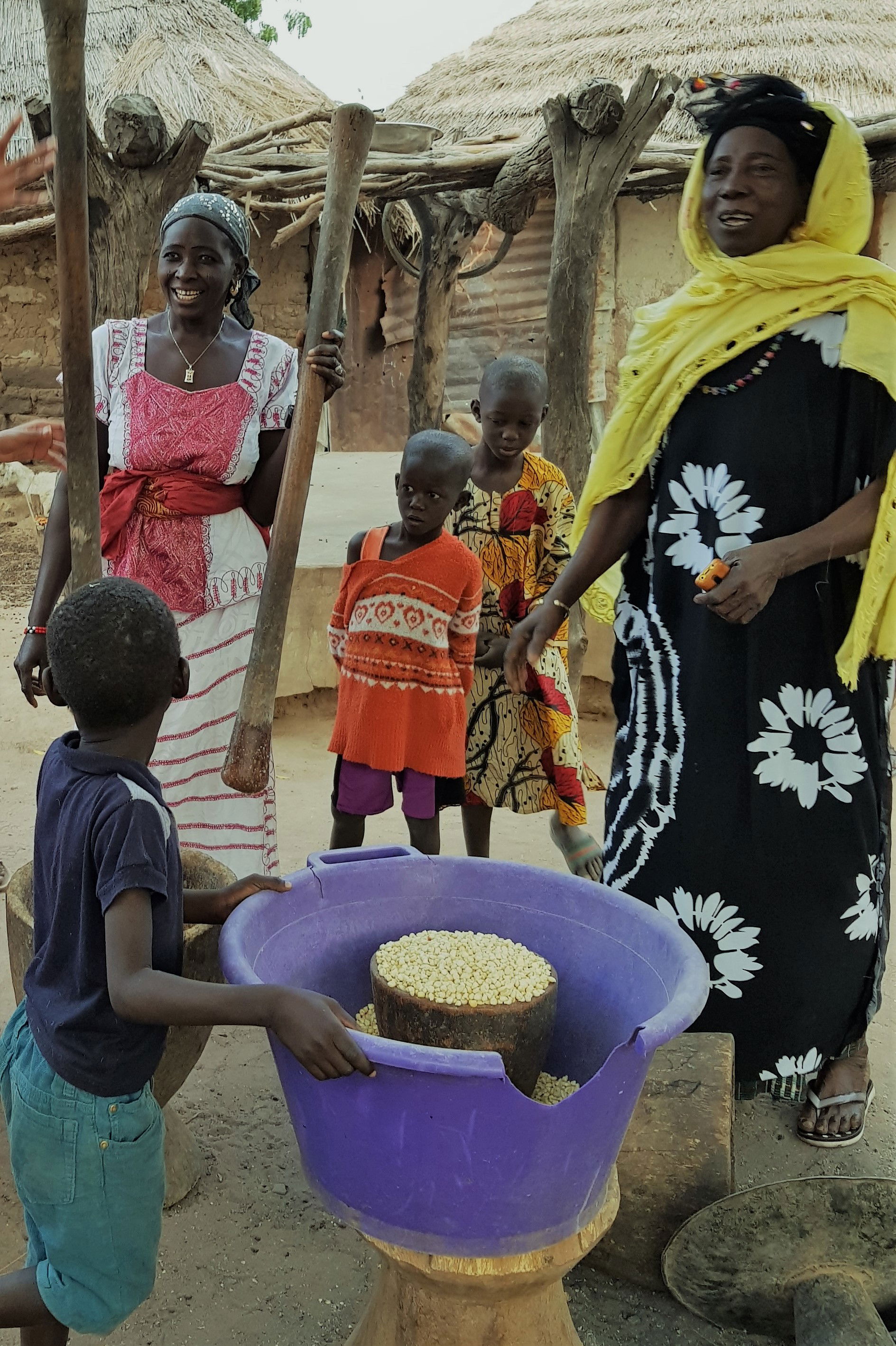 Women in Sutukoba hand-milling the grain for breakfast