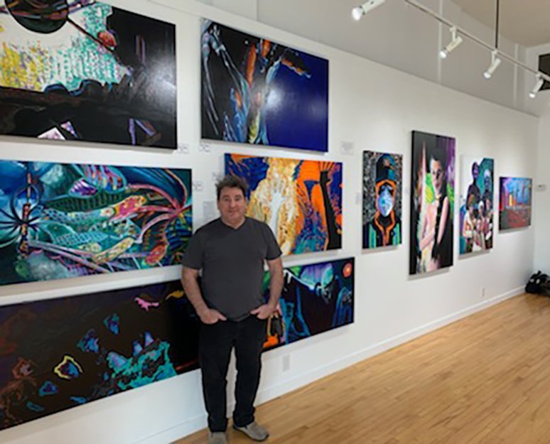 Artist with some paintings in the "Awakening" exhibition