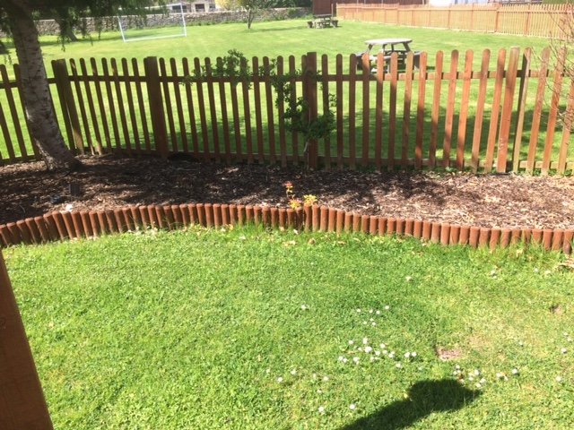 Picket fencing with logged lawn edging
