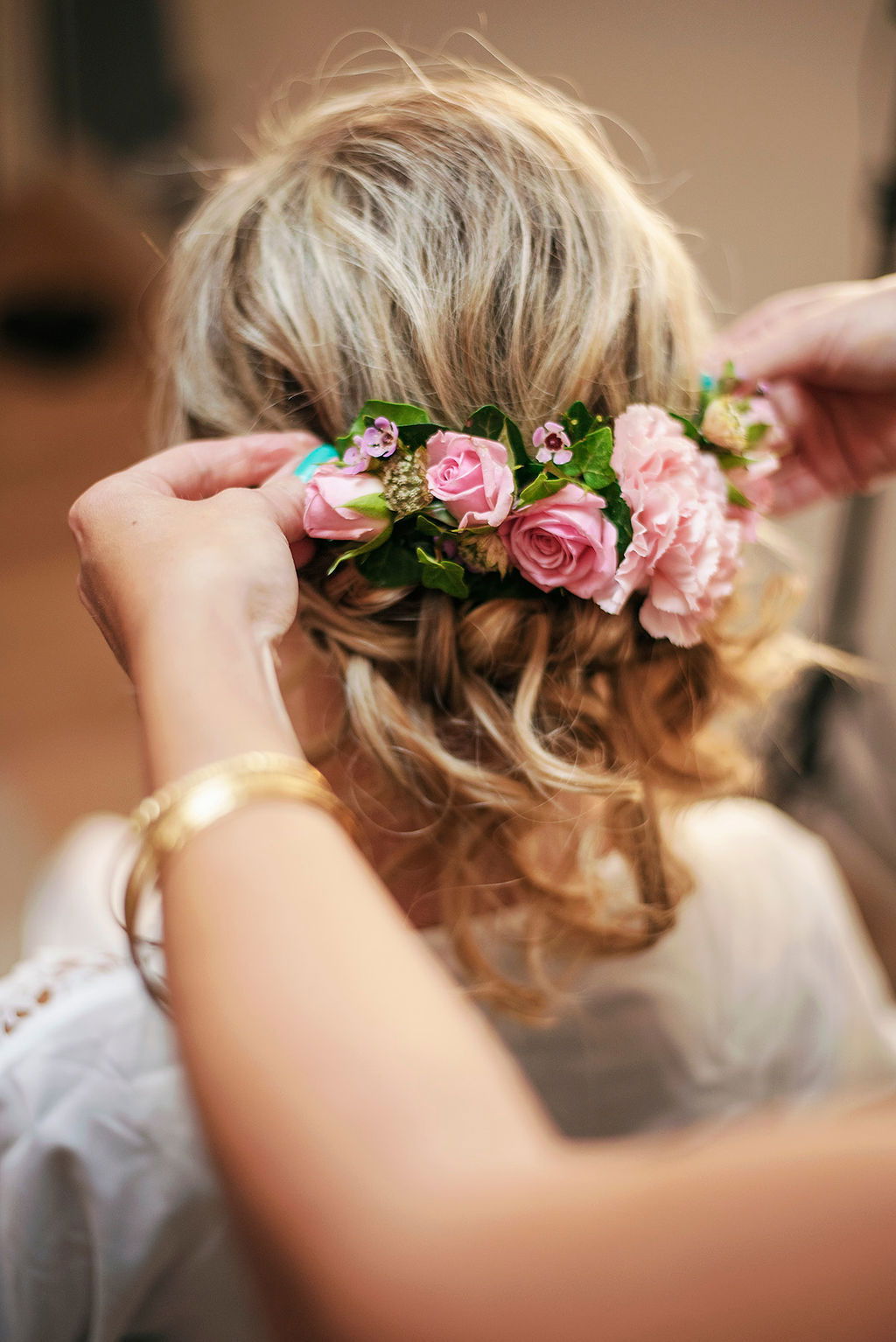 Coiffure mariage chignon bas chic et romantique avec demi couronne de fleurs roses