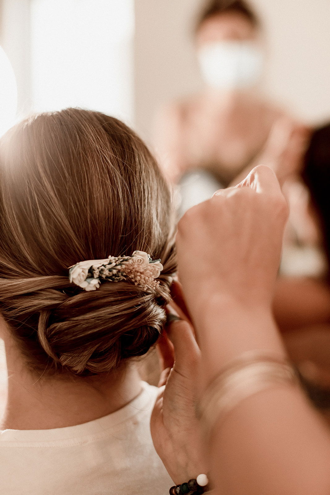 Coiffure mariage chignon bas romantique et bijou fleuri