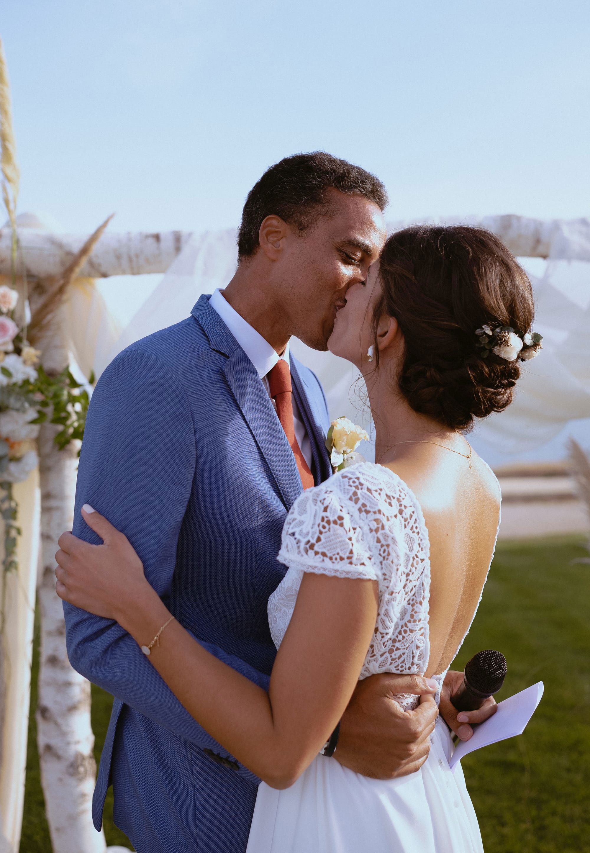 Chignon bas de mariée travaillé d'une base boucle avec bijoux de fleurs blanches