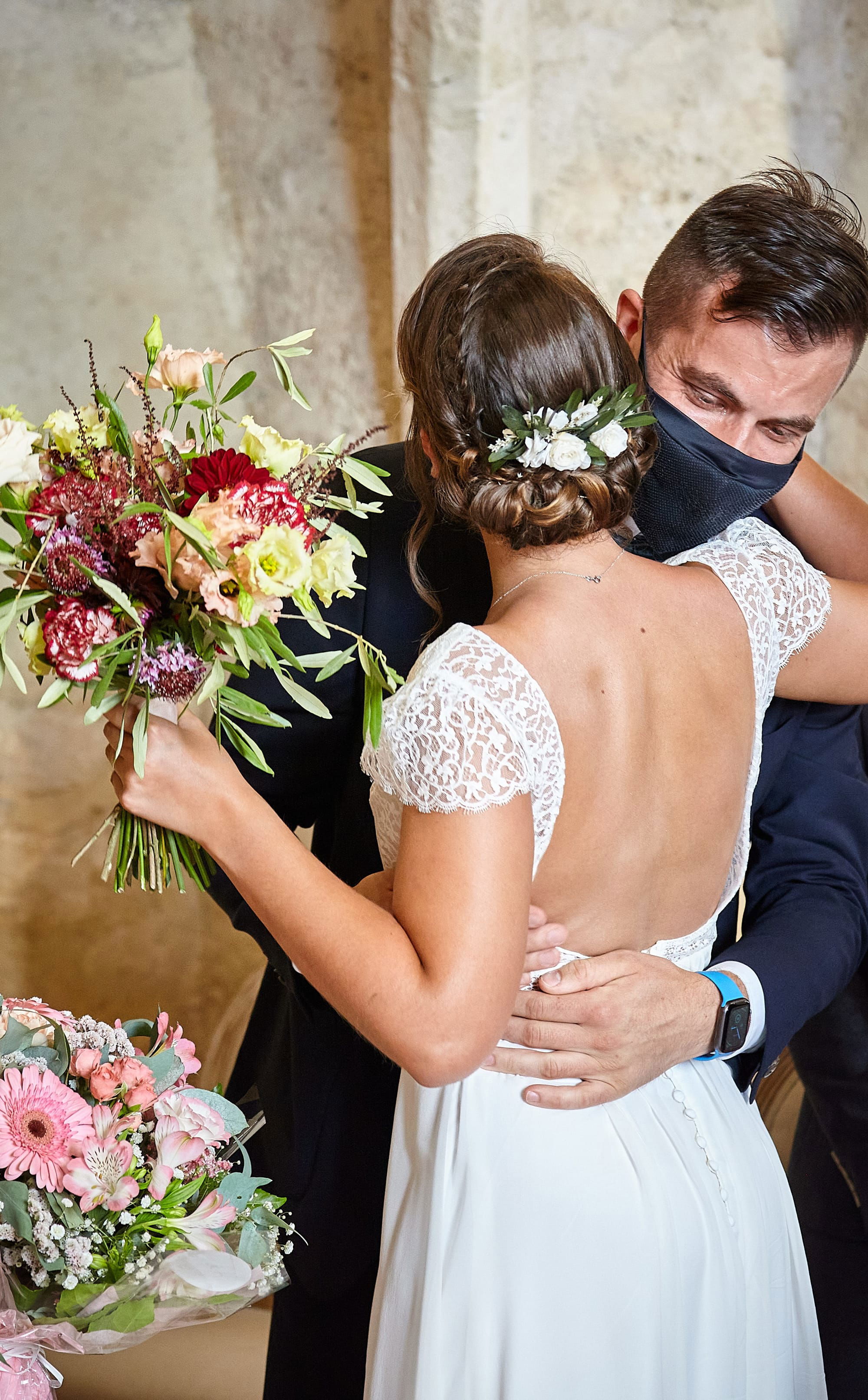 Chignon flou et bas de mariée avec fleurs fraîches