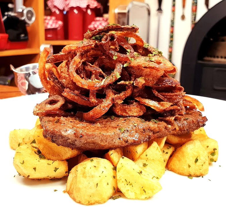 Tender grilled pork steak topped with hay of onion (Hagymas rostelyos)