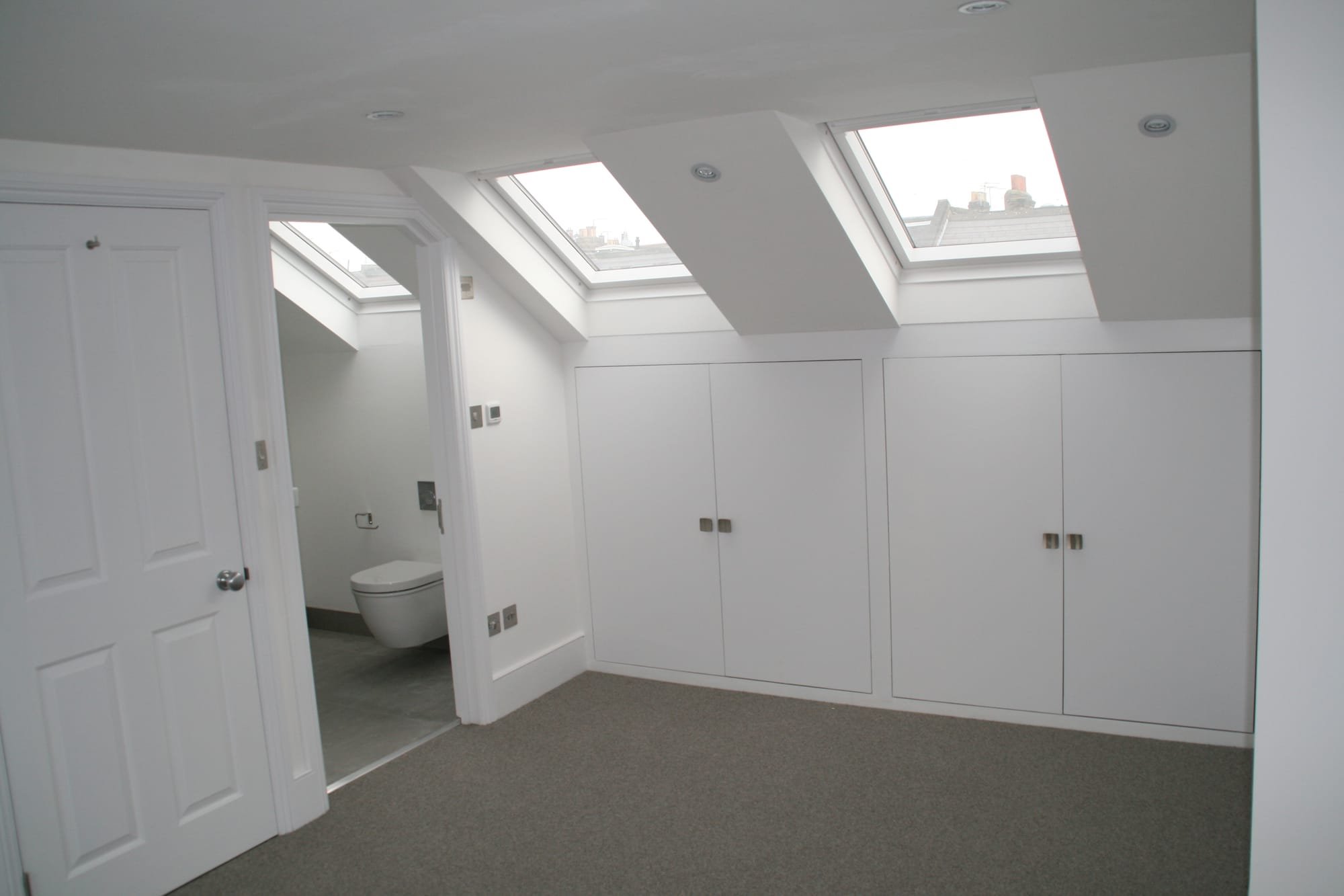 Bedroom eaves storage in this SW11 London loft with velux in bedroom and en-suite bathroom