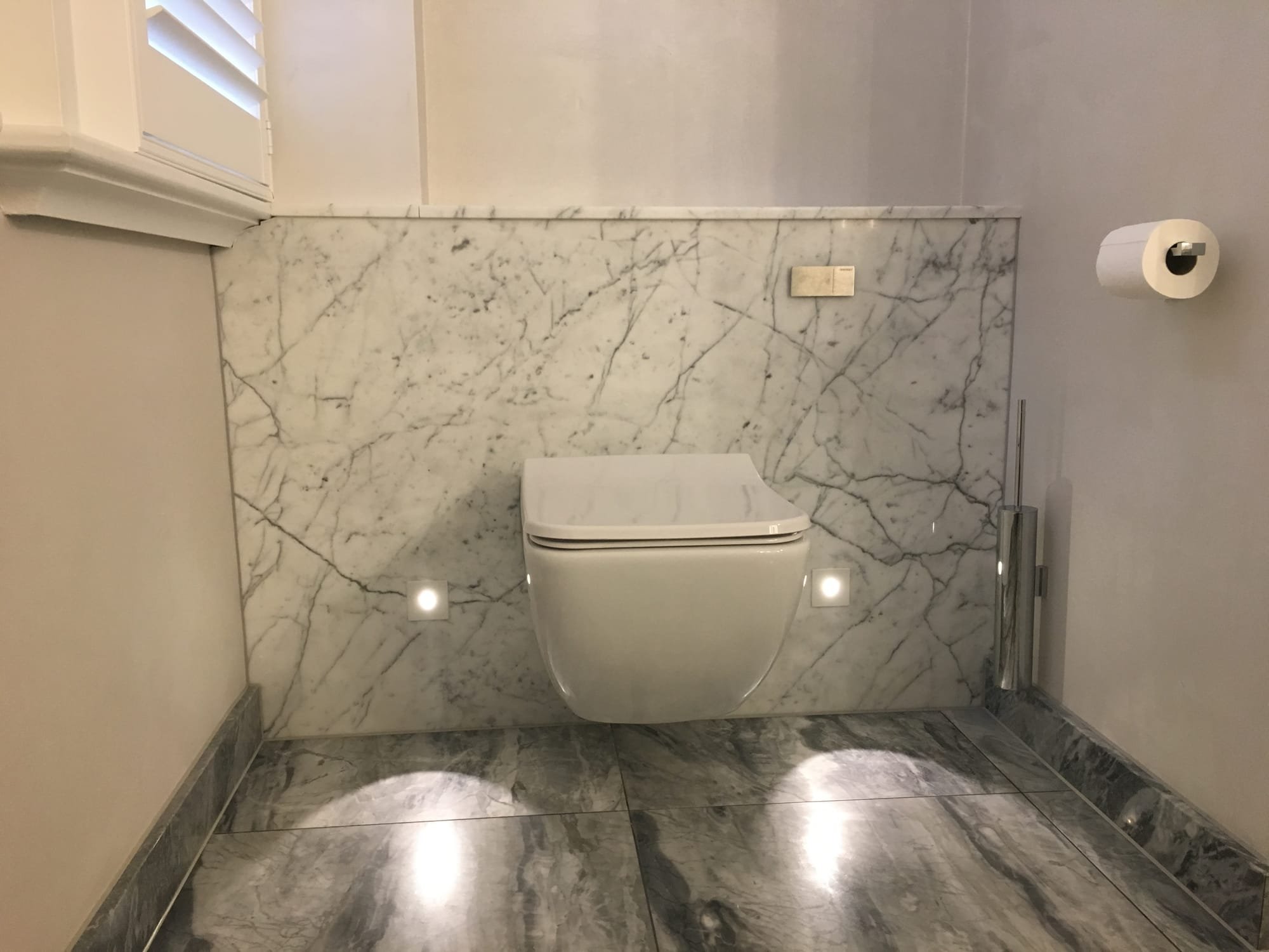 Marble concealed cistern to this wall mounted loo with low level LED marker lights on a PIR