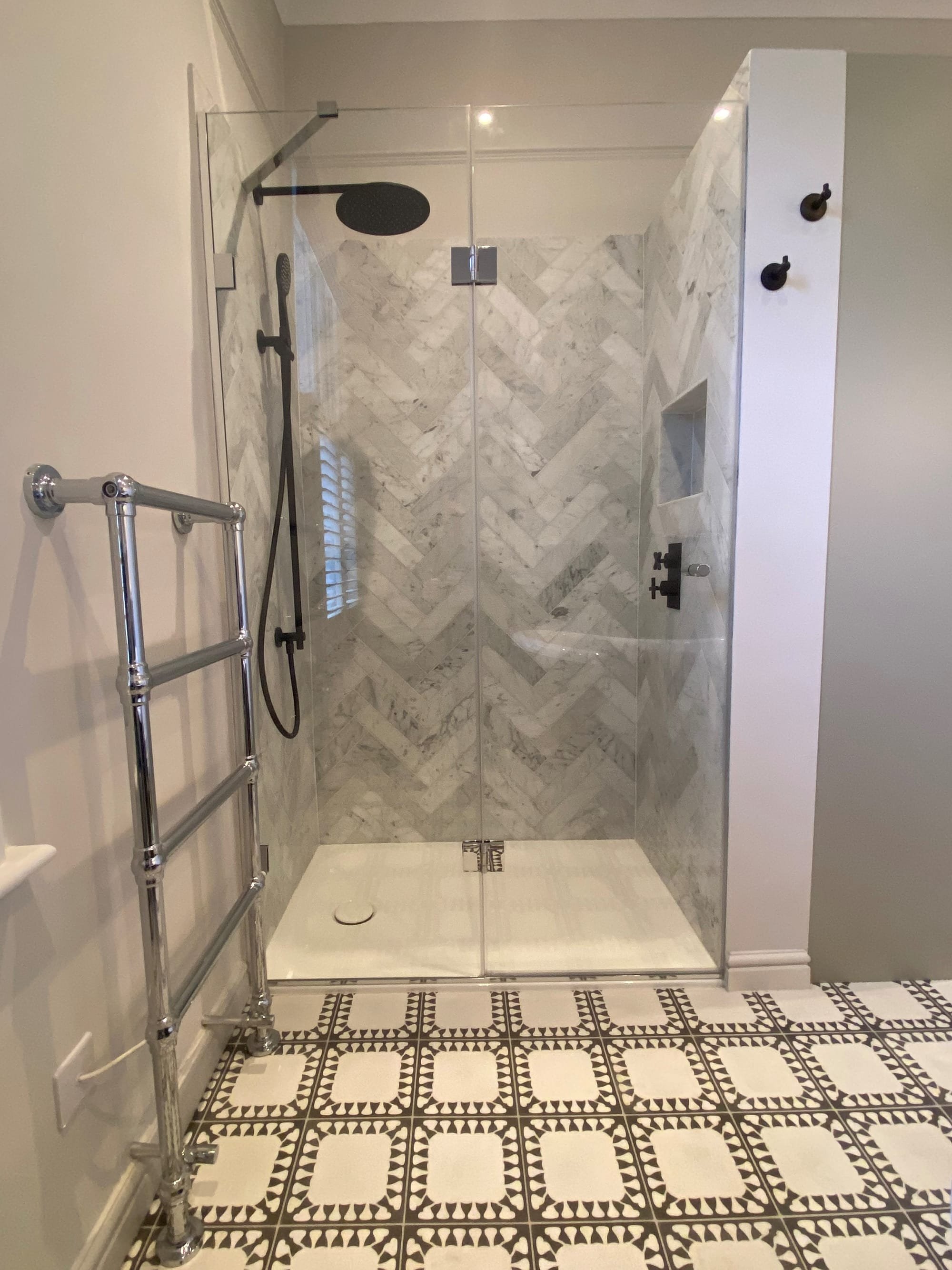 Herringbone marble tiles in this SW12 bathroom shower