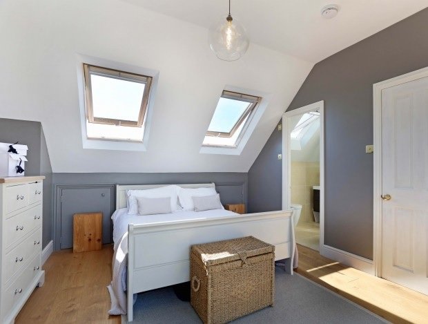 Wandsworth loft conversion with eaves storage hidden behind bed and en-suite loft bathroom.