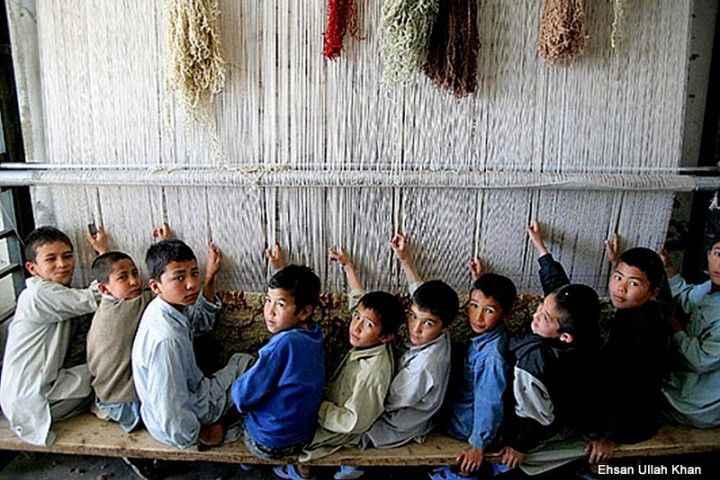 29. Niños pakistaníes trabajando en la fabricación de alfombras.