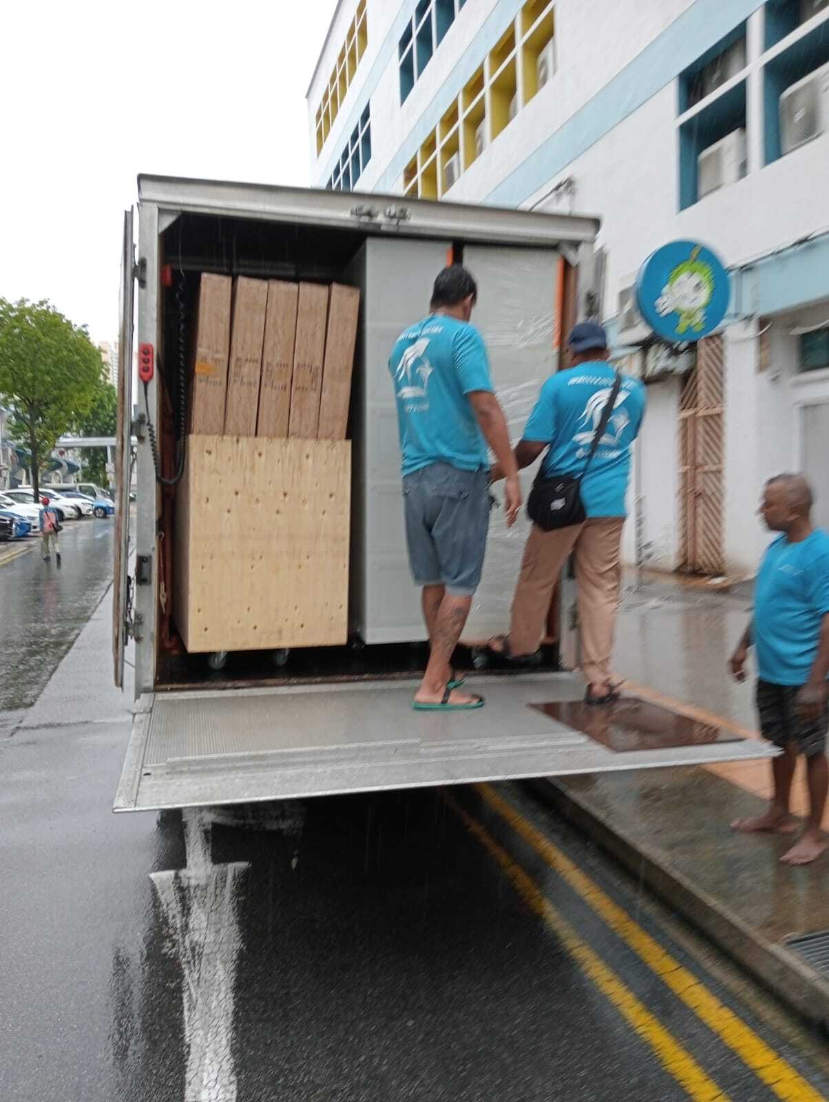movers loading packed furniture into truck